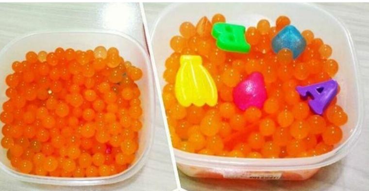 Caixas sensoriais com bolinhas de gel e letras coloridas